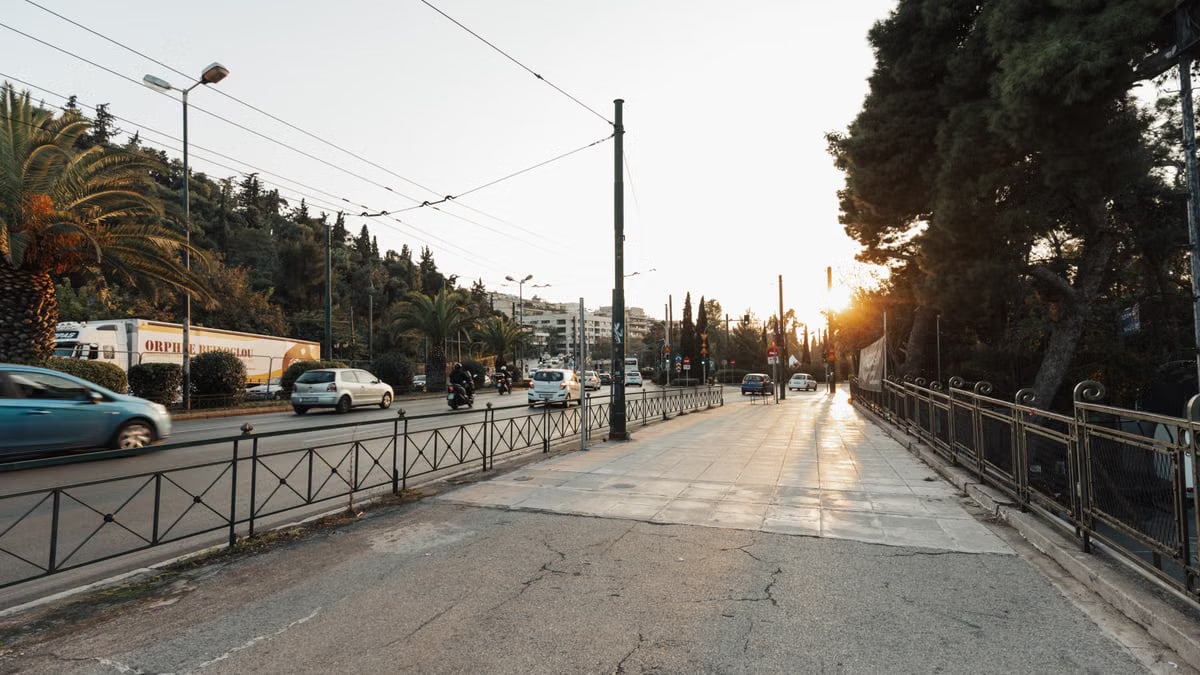 A sunlit urban street scene at sunset with light traffic, capturing the essence of city life.
